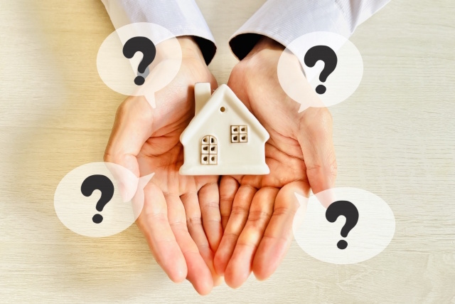 手のひらに家のオブジェが乗っているところ