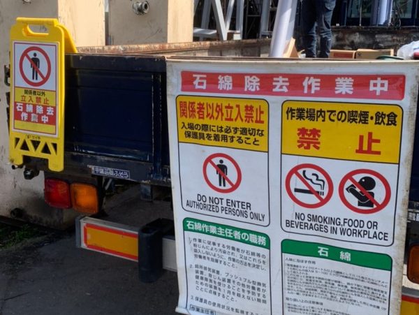 株式会社エイキのトラックリアゲートに吊るしてあるアスベスト除去現場での掲示板。主任者の職務と石綿についての危険性が記載してある