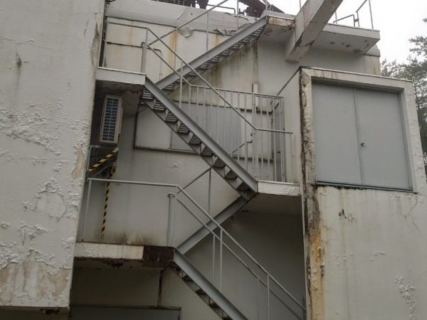 エイキが過去にアスベスト除去を行った現場写真。外壁の塗膜が所々剥がれている